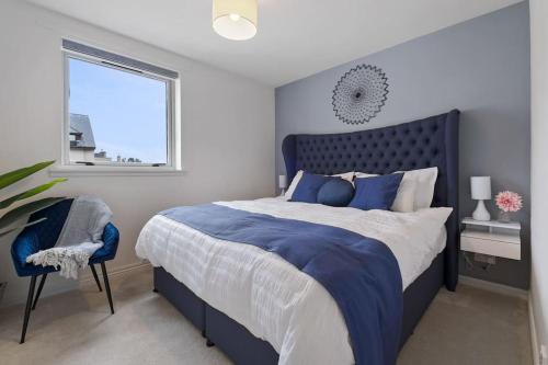 a bedroom with a blue and white bed and a window at Boutique Beachside Apartment with Jacuzzi Bath, Findhorn in Findhorn