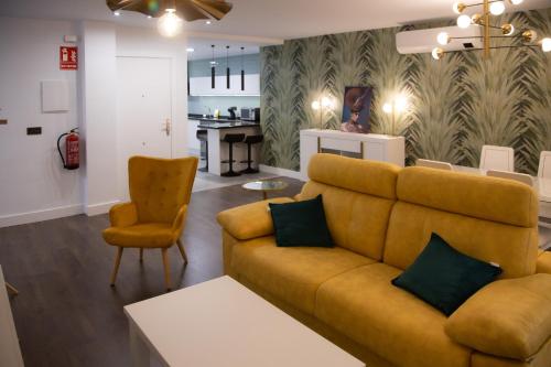 - un salon avec un canapé et une chaise dans l'établissement Apartamentos Boutique Cervantes, à Plasence
