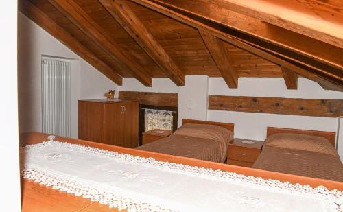 2 bedden in een kamer met houten plafonds bij Stars Apartments Gressan in Cerise