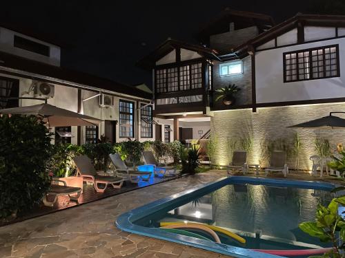 uma casa com piscina à noite em Pousada Las Ondas em Garopaba