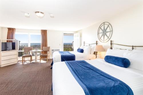 a hotel room with two beds and a television at Dune Crest Hotel in North Truro