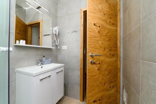 a bathroom with a white sink and a mirror at Rooms FOREVER in Miholašćica