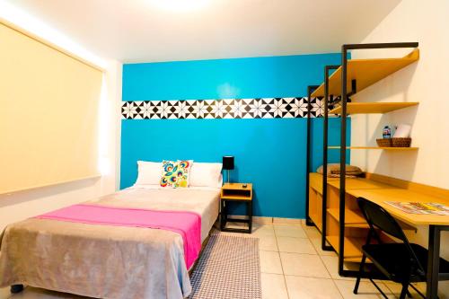 a small bedroom with a bed and a desk at Hotel Casa Blanca Minero in Fresnillo de González Echeverría