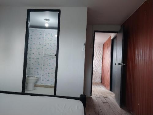 sypialnia z lustrem i łóżkiem oraz łazienka w obiekcie El Remanso del Santuario w mieście Camarones