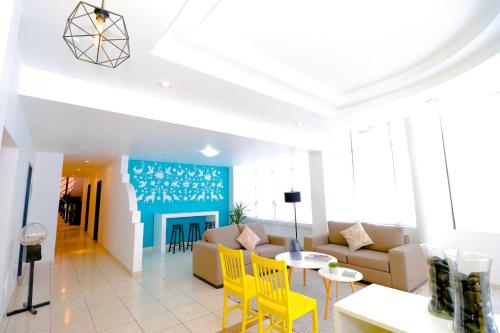 a living room with yellow chairs and a couch at Hotel Casa Blanca Minero in Fresnillo de González Echeverría