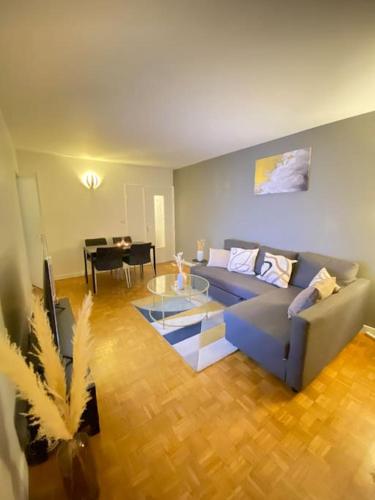 un salon avec un canapé bleu et une table dans l'établissement Superbe appartement proche de Paris, à Colombes