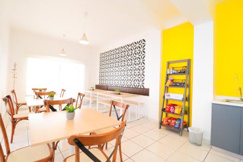 une salle à manger avec des murs et des tables jaunes et blancs dans l'établissement Hotel Casa Blanca Minero, à Fresnillo de González Echeverría