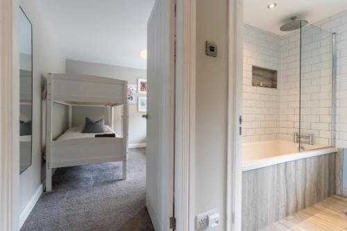 1 dormitorio con 1 cama y baño con bañera. en No40Barmouth-Modern,Spacious&Hot Tub, en Barmouth