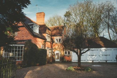 una casa con un árbol delante de ella en Hampton Manor, en Hampton in Arden