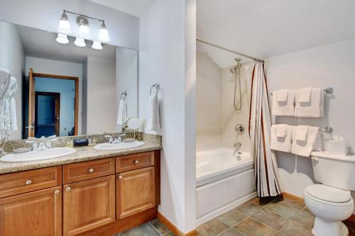 a bathroom with two sinks and a tub and a toilet at Ski In Out Luxury Penthouse #1706 With Hot Tub & Great Views - 500 Dollars Of FREE Activities And Equipment Rentals Daily in Winter Park