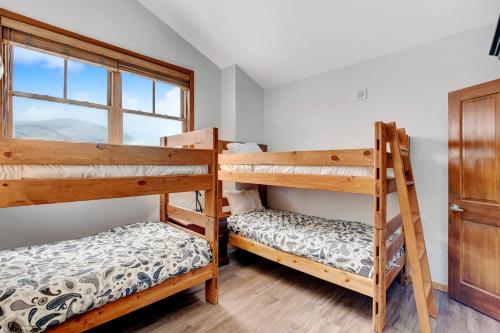 two bunk beds in a room with a window at Ski In Out Luxury Penthouse #1706 With Hot Tub & Great Views - 500 Dollars Of FREE Activities And Equipment Rentals Daily in Winter Park