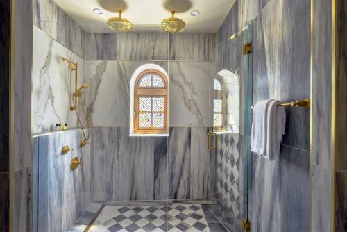 ein Bad mit einer ebenerdigen Dusche und einem Fenster in der Unterkunft The Villa Casa Casuarina in Miami Beach