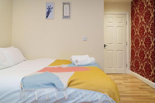 um quarto com uma cama com um cobertor colorido em Roundhay Apartments em Leeds