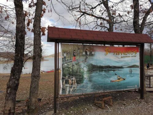 a bus stop with a large advertisement at a lake at The Lady of the Lake in Kalyvia