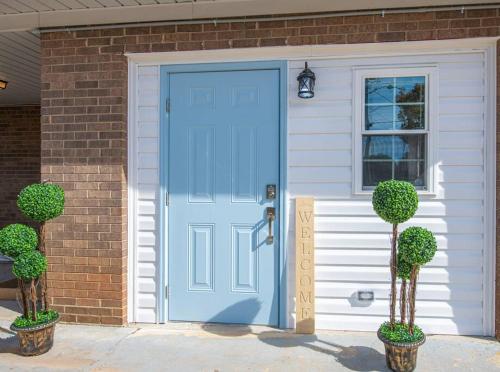una puerta azul en una casa con dos árboles en TheCozyCorner in Concord en Concord
