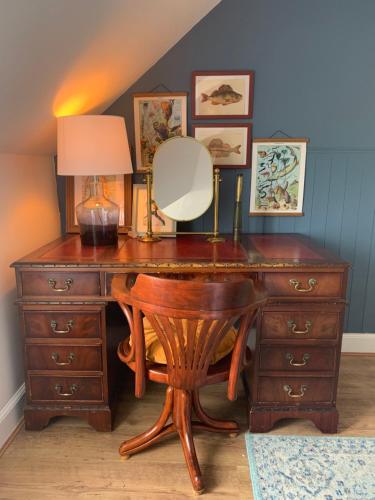 a wooden desk with a mirror and a lamp on it at This must be the place - Arran, Lamlash in Lamlash
