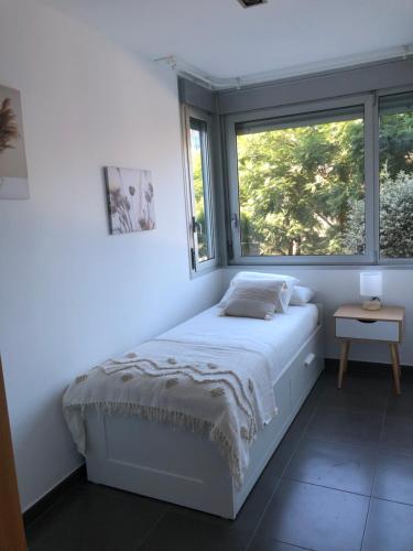 a white bedroom with a bed and a window at Standing Apartment Barcelona Forum in Barcelona