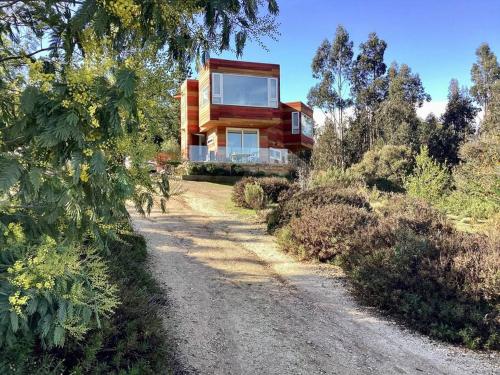 a house on a hill with a dirt road at Agradable casa de campo 2 pisos con piscina y Hot Tub in Algarrobo