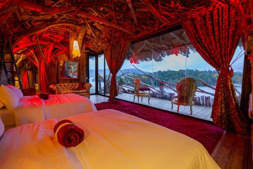 a bedroom with two beds and a large window at Bethel Lozana Guatape in Guatapé