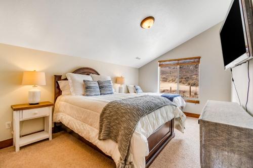 - une chambre avec un lit, une télévision et une fenêtre dans l'établissement Peaceful Bear Lake Home, à Garden City
