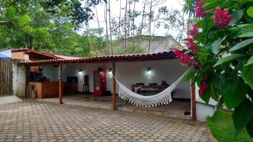 eine Veranda eines Hauses mit einer Hängematte darauf in der Unterkunft Pousada Caminhos da Chapada in Palmeiras