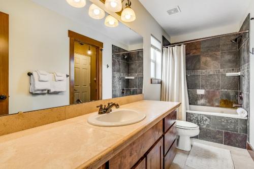 La salle de bains est pourvue d'un lavabo, de toilettes et d'un miroir. dans l'établissement Peaceful Bear Lake Home, à Garden City
