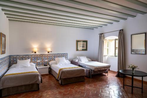 a hotel room with two beds and a table at Parador de Almagro in Almagro