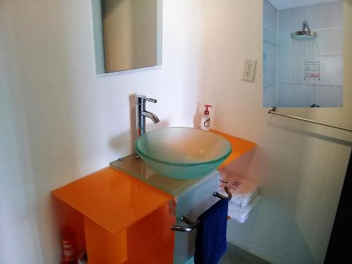 baño con lavabo verde y espejo en Swim the Caribbean & Work with a View en Cancún