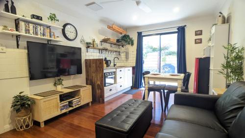 salon z kanapą i telewizorem z płaskim ekranem w obiekcie Frostwood House w mieście Mount Barker
