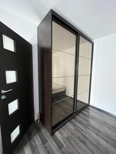 ein Zimmer mit einer schwarzen Tür und einem Spiegel in der Unterkunft Mall Vitan studio Eveline in Bukarest