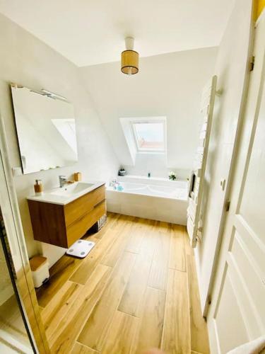 une salle de bain avec un lavabo et une baignoire dans l'établissement Maison ancienne rénovée Bord de loire, à Ingrandes