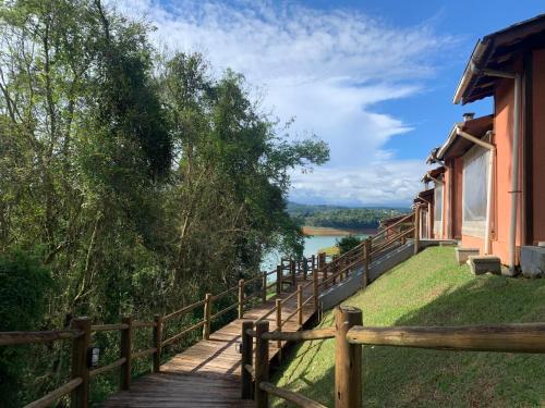a wooden pathway leading up to a building with a view of a river at Chalé das Águas in Igaratá