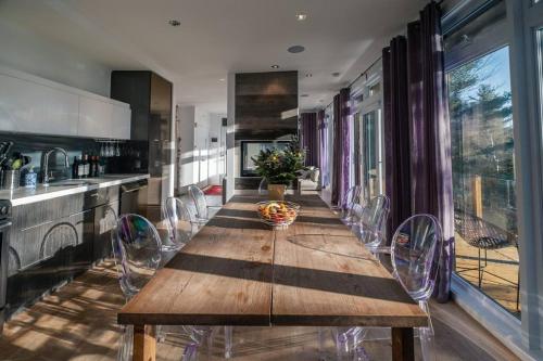 una cocina con una mesa de madera larga y sillas en Chalet DesignPur on the lake en Chertsey