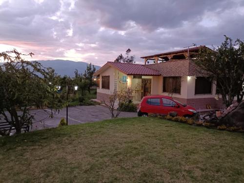 a red car parked in front of a house at Casa de campo Pillaro - Activa in Píllaro