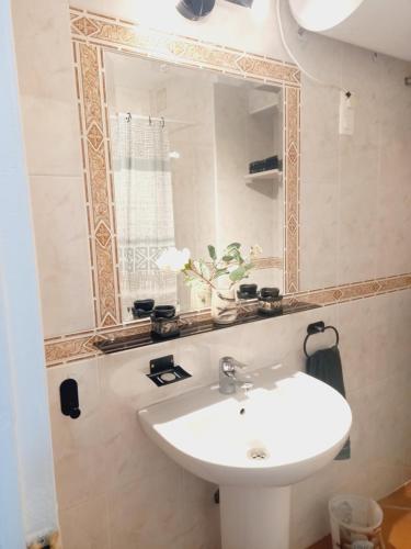 uma casa de banho com um lavatório branco e um espelho. em Aquamarina sea view em Benalmádena