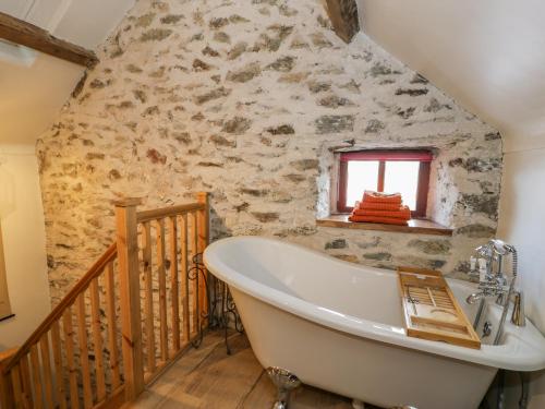 Cwch Gwenyn في هوليهيد: حوض استحمام في الحمام بجدار حجري