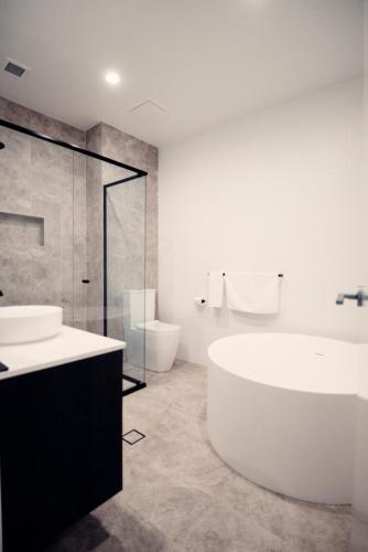 Un baño con bañera, lavabo e inodoro. en Warners at the Bay, en Warners Bay