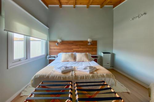 1 dormitorio con 1 cama grande y cabecero de madera en CASA COIHUE en El Chaltén