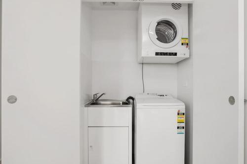 a small kitchen with a microwave above a refrigerator at Great Corporate One Bedroom ATC006911 in Sydney