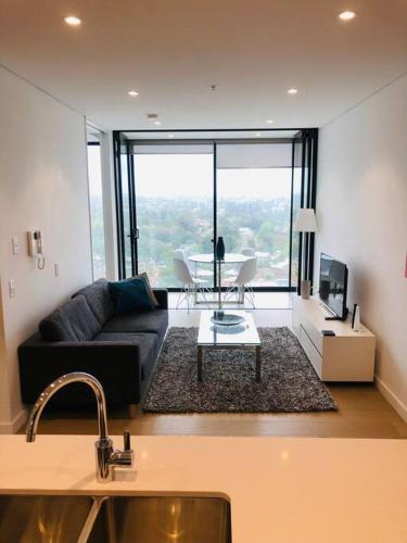 a living room with a couch and a table at Great Corporate One Bedroom ATC006911 in Sydney