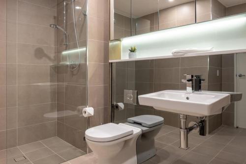 a bathroom with a toilet and a sink and a shower at Great Corporate One Bedroom ATC006911 in Sydney