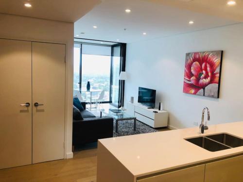 a kitchen and a living room with a couch at Great Corporate One Bedroom ATC006911 in Sydney