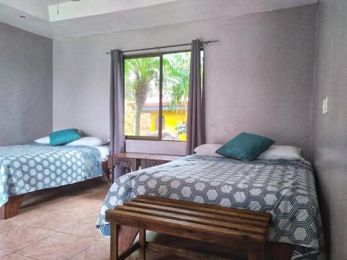 1 dormitorio con 2 camas y ventana en Regenerate Wellness Center at Villas Escondidas, en Grecia