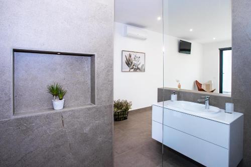 ein Bad mit einem Waschbecken und einem Spiegel in der Unterkunft Villa Macán in Teguise
