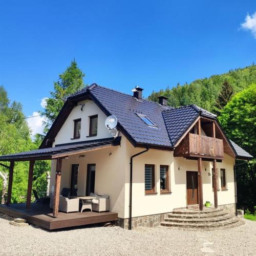 une petite maison blanche avec un toit dans l'établissement Dom nad rzeką, à Nowy Gierałtów