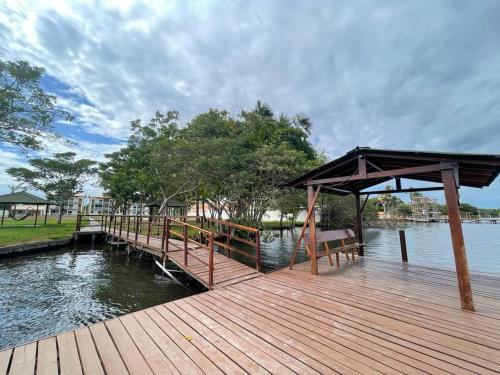 a wooden dock with a bench on the water at Lençóis Confort 201 in Barreirinhas