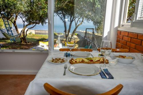a table with glasses of wine and food on it at House Ana in Banj
