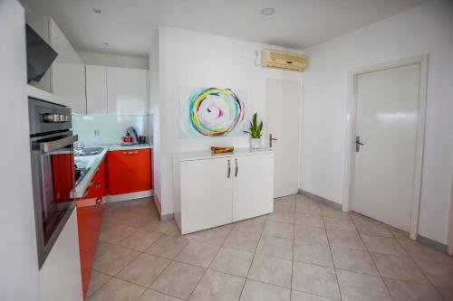 a kitchen with white cabinets and a plate on the wall at House Ana in Banj