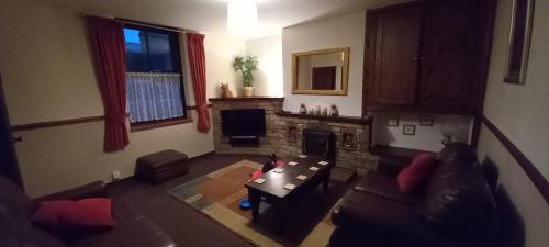 uma sala de estar com um sofá e uma lareira em Cumbrian cottage, sleeps 6, in convenient location em Tebay