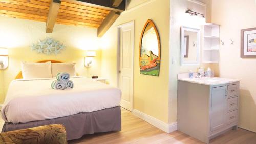 a bedroom with a large bed and a sink at Maui Westside Presents: Papakea J401 Top floor Ocean Views in Lahaina
